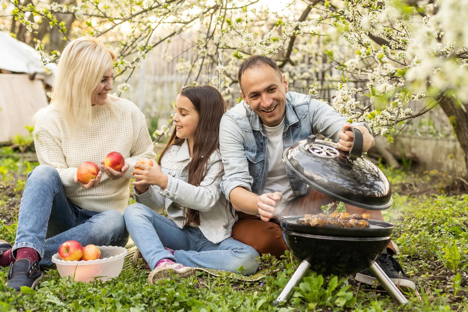 A pellet grill smoking food on a backyard patio at golden hour
