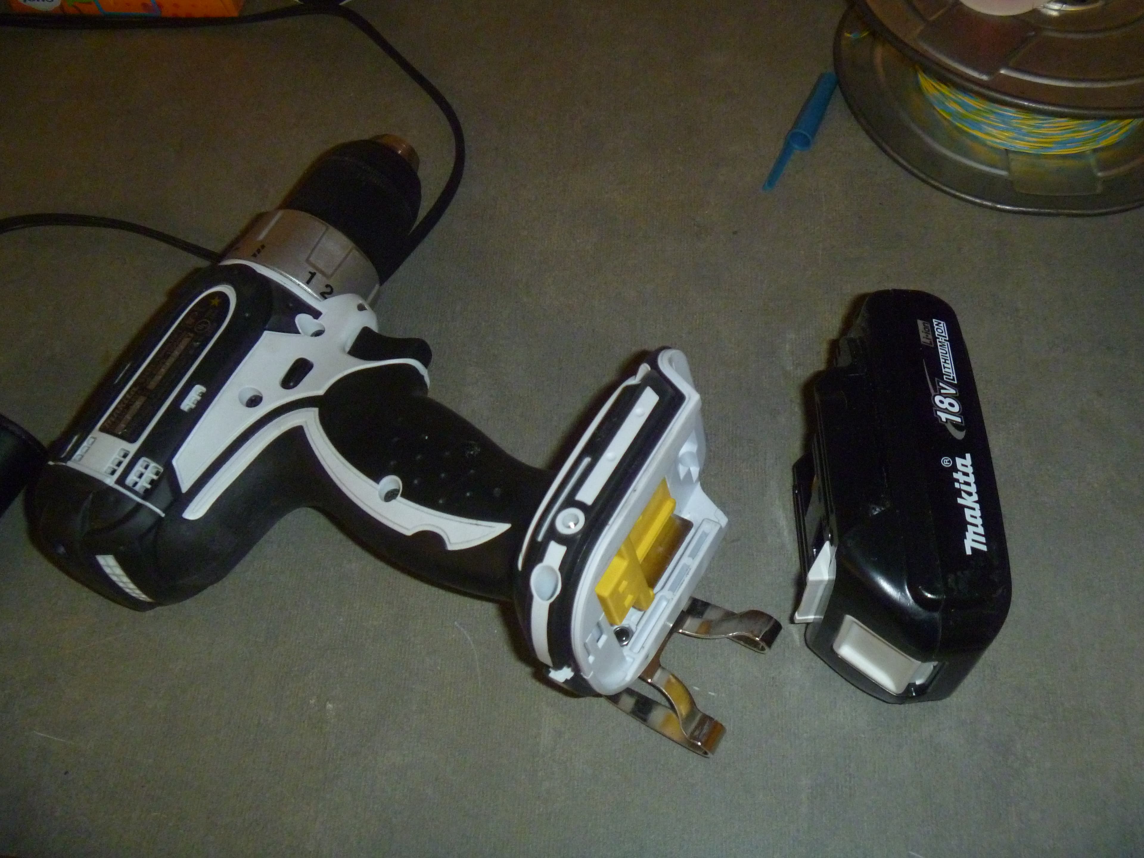 A battery pack being removed from a cordless drill, illustrating the proprietary battery platform behind every cordless tool