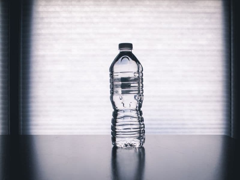 A glass being filled with clean filtered water on a sunlit kitchen counter