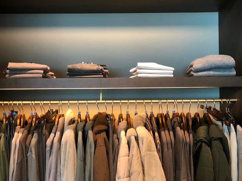 A neat, organized closet of clothes hanging on matching hangers