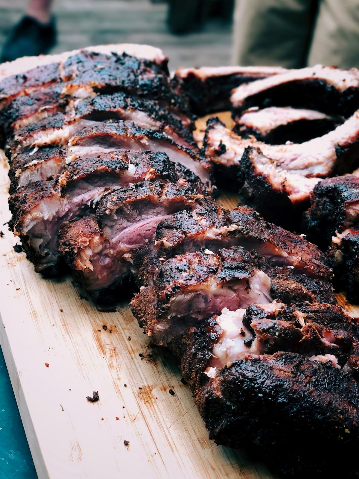 A pellet grill smoking food on a backyard patio at golden hour