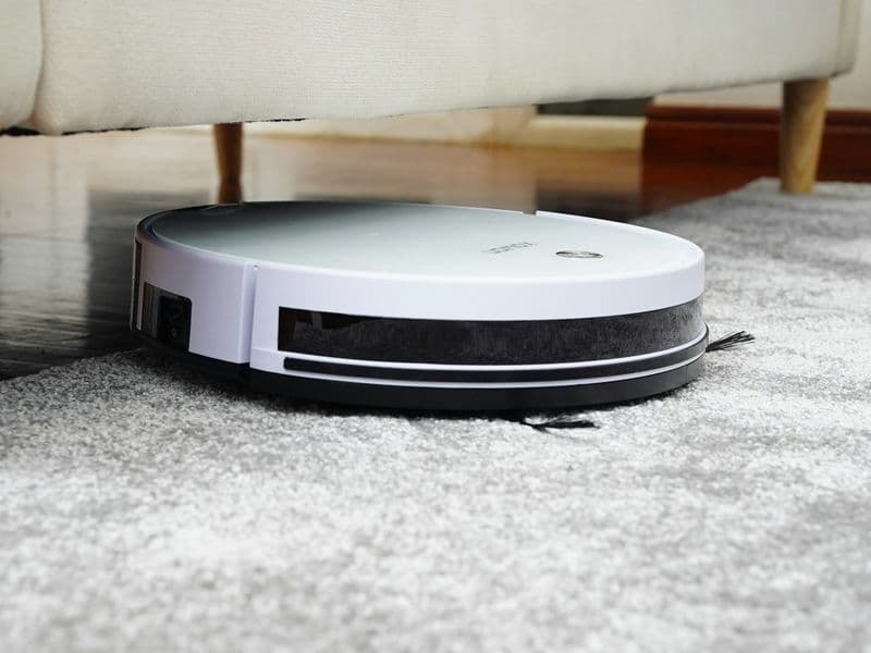 Bright modern living room with hardwood floors and a rug, the kind of mixed-surface home a floor vacuum has to handle