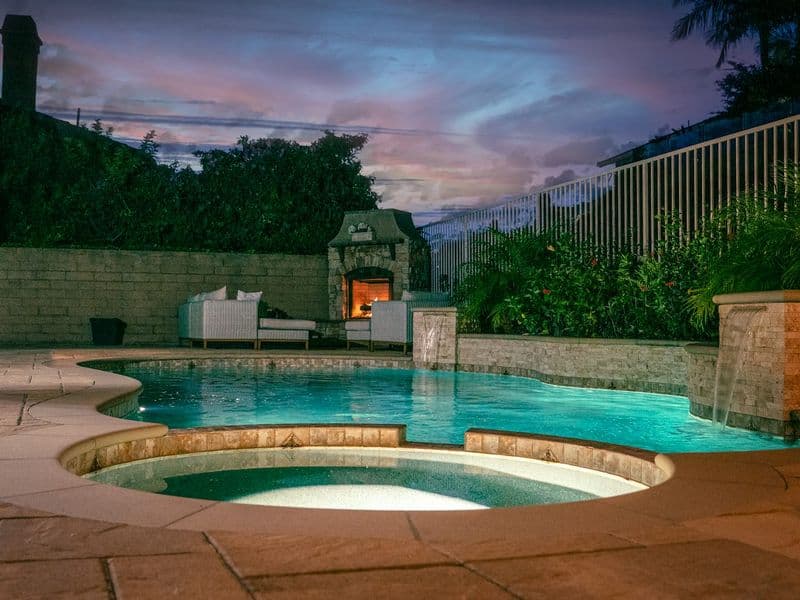 Clean, sunny backyard swimming pool with sparkling blue water