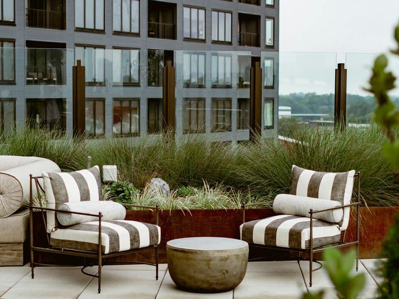 Cozy outdoor patio with a cushioned couch, chairs, and potted plants