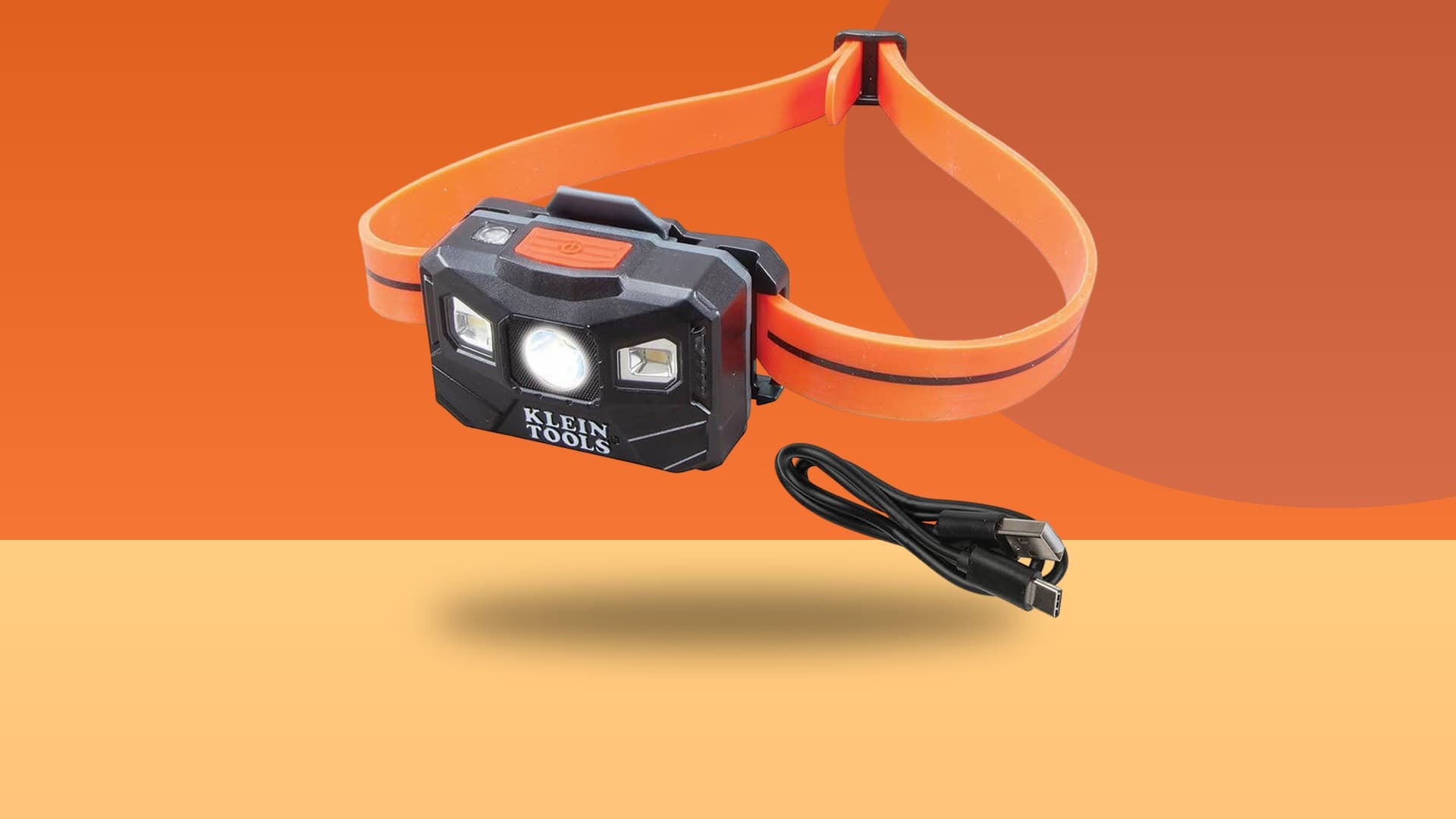 Klein Tools 56064 400-lumen rechargeable headlamp with silicone strap and USB-C charging cable on a colorful background