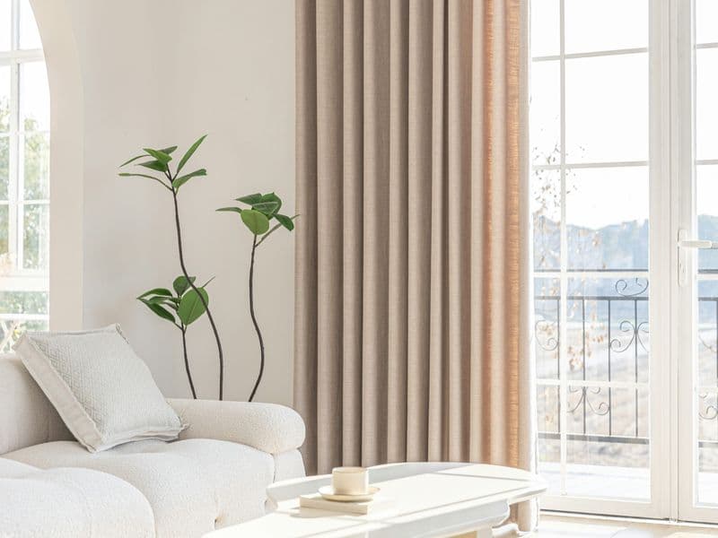 Bright living room with neutral floor-to-ceiling linen curtains and soft natural light