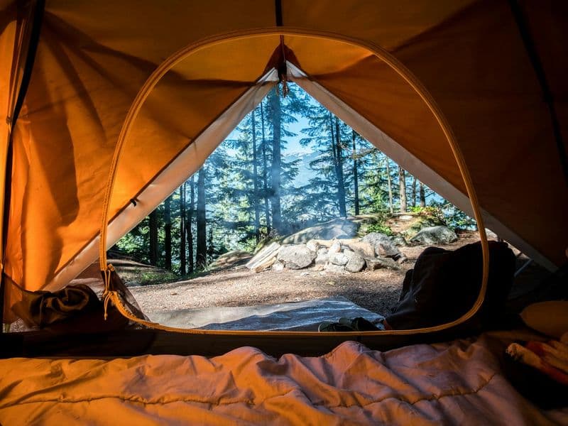Outdoor campsite by a lake at golden hour, the kind of group outing a large wheeled cooler is built for