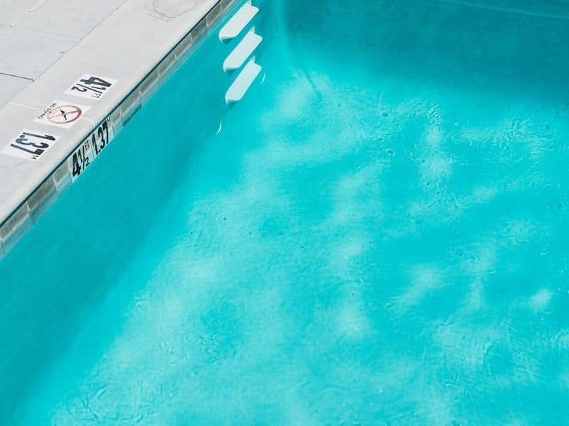 Sunlit backyard swimming pool with clean blue water